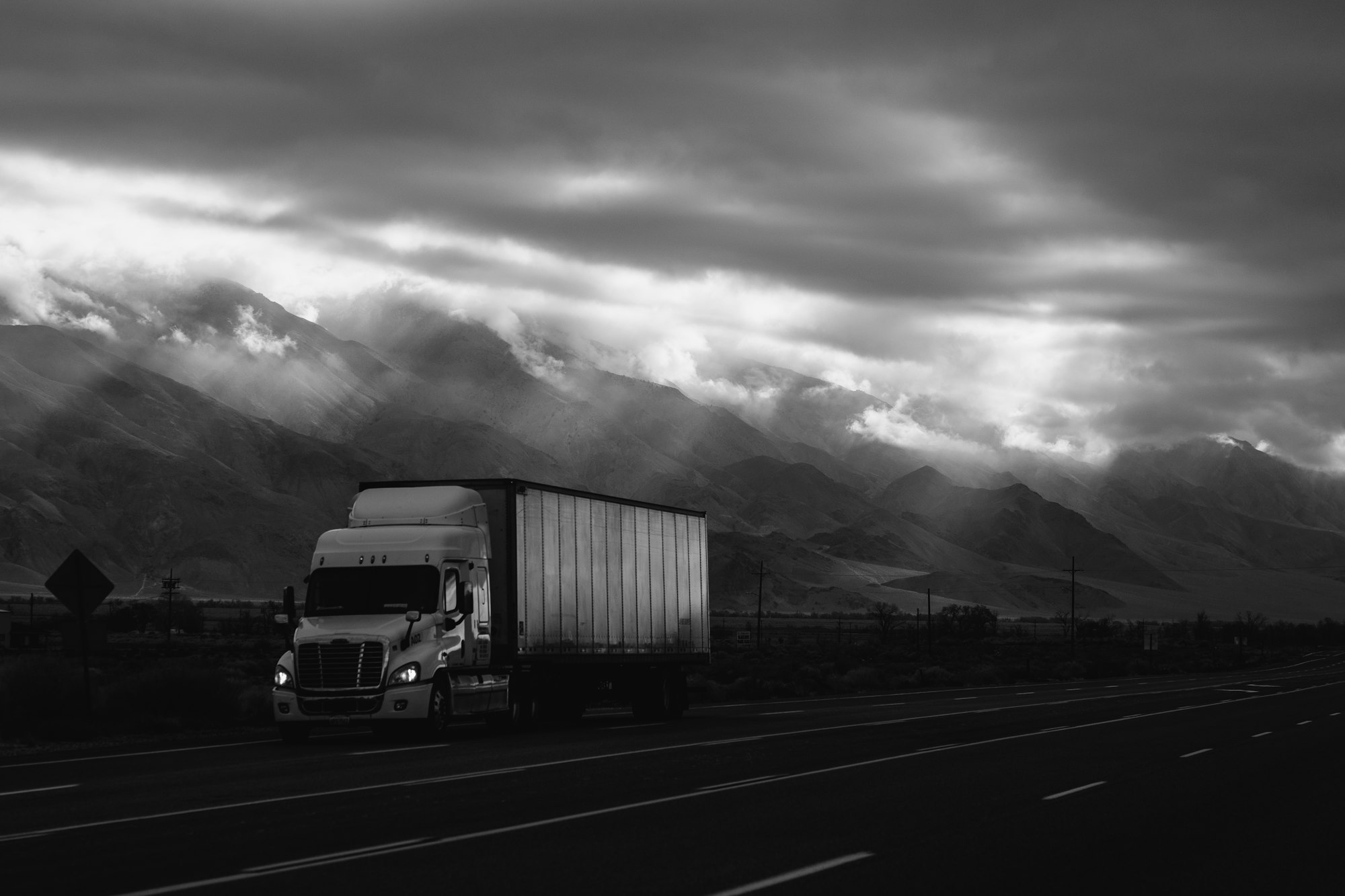 Freight truck on the road under heavy sky
